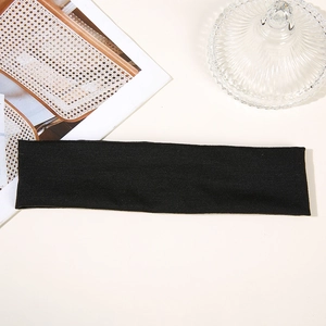 Flat lay of a black sweatband for running and yoga on a minimalist desk setup