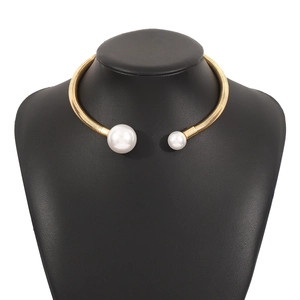 Macro detail of gold spiral choker necklace featuring asymmetrical white pearls on model