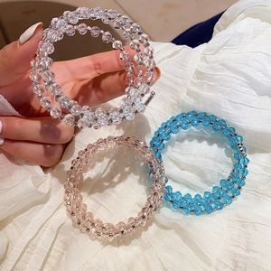 Detailed macro view of triple-layered crystal bead bracelets in clear, pink and blue