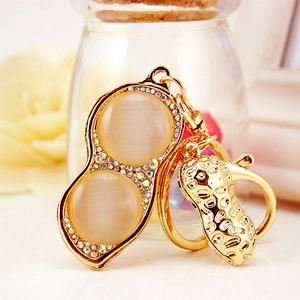 Peanut cat's eye stone keychain with rhinestones and gold-plated metal charms