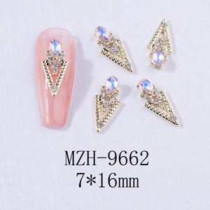 Detailed view of teardrop and triangle alloy nail rhinestones with gold finish