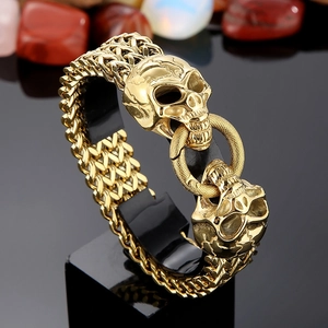 Detailed view of golden stainless steel skull bracelet on professional black display stand