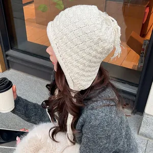 Winter chunky knit white earflap beanie with braided tassels for warm outdoor styling