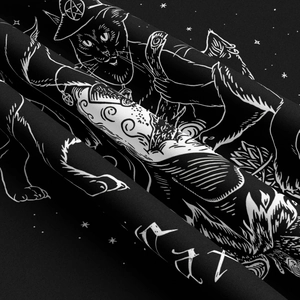 Detailed macro view of the black fabric texture and mystical cat print on the tapestry