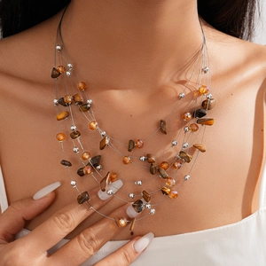 Close-up of bohemian layered necklace featuring tiger eye stones and metallic beads