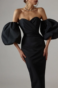 Detail of elegant black off-shoulder cocktail dress with dramatic puff sleeves texture