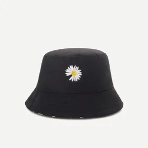 Detail shot of a black bucket hat featuring a white daisy embroidery with yellow center