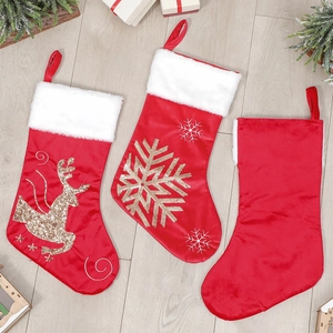 Three red velvet Christmas stockings with gold sequin reindeer and snowflake embroidery