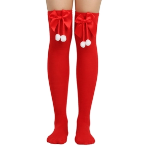 Detail of red over-knee socks featuring large satin bows and white plush pom-poms