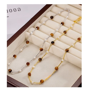 Detail of beaded 925 silver necklaces with tiger eye stones and pearls on display