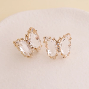 Macro shot of 925 silver needle butterfly earrings with gold plating and clear crystals