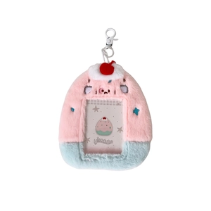 Pink and blue plush card holder with cherry decoration and metal clip on white background