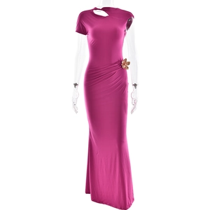 Detail of the rose red fishtail dress featuring a one-shoulder cut and golden flower brooch