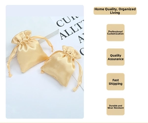Pair of champagne satin drawstring pouches for jewelry storage on white minimalist stand