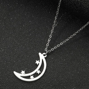 Close-up of a silver crescent moon pendant with three stars on a delicate link chain