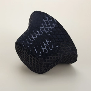 Dettaglio cappello pescatore nero con paillettes e trama a rombi con riflessi luminosi