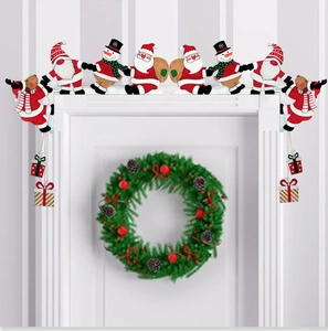 Detailed view of wooden Santa and snowman ornaments mounted on a white door frame corner