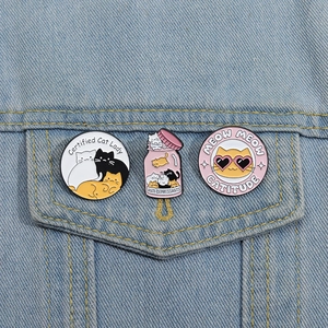 Three cute enamel cat pins on denim jacket featuring unique creative slogans