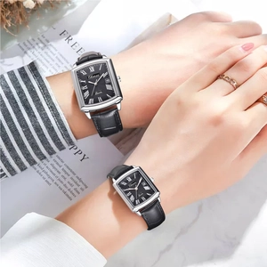Close-up of couple wearing silver square quartz watches with black leather straps