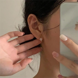 Minimalist 925 sterling silver cat eye stud earrings shown in a soft mirror selfie style