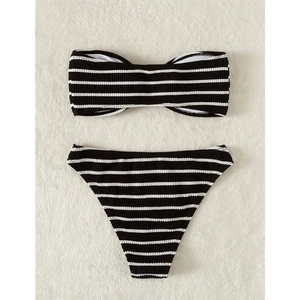 Detailed flat lay of striped bikini with ribbed texture on soft plush carpet background