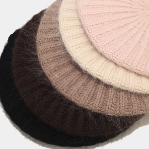 Close-up of fuzzy knit berets in five colors showing soft angora rabbit hair texture