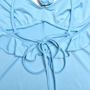 Detail of light blue backless dress featuring cross-tie lace and ruffled hem decoration