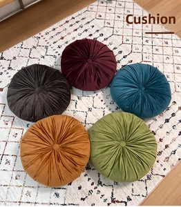 Detailed close-up of velvet pumpkin cushions showing pleated fabric and center button