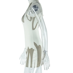 Detail of slim-fit sleeveless mini dress featuring abstract brown prints on cream fabric