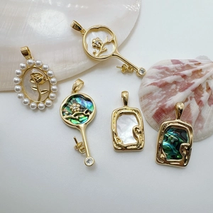 Detail of 18K gold-plated charms with baroque rose shells and abalone pearl textures