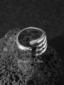 Detailed view of silver claw open ring with 1.9cm diameter measurement on volcanic rock