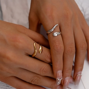 Close-up of minimalist gold and silver snake rings worn on a hand to show scale