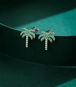 Macro detail of S925 sterling silver coconut tree earrings with green gemstones