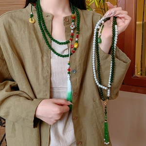Détail du collier à pompon chinois avec perles de jade vert et perles blanches sur modèle