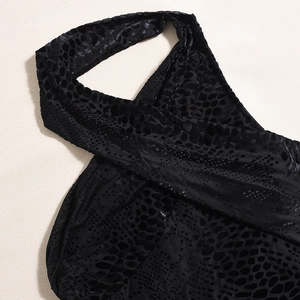 Close-up of black snake-pattern embossed velvet fabric with elegant halter neckline detail