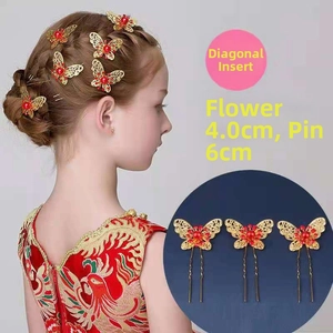 Detail of gold hollow butterfly hair pins with red beads for bridal hair styling