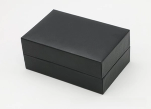 Macro shot of rectangular black PU leather watch box with fine litchi texture and flip lid