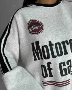 Close-up of retro racing-style embroidery and motor print on grey crewneck sweatshirt