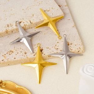 Detail of four-pointed star charms in gold and silver finish on a travertine stone