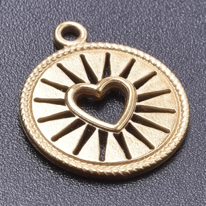 Detailed macro view of 18k gold plated stainless steel heart pendant with sunburst texture