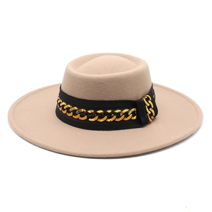 Detail of beige wide brim felt fedora with black ribbon and gold chain embellishment