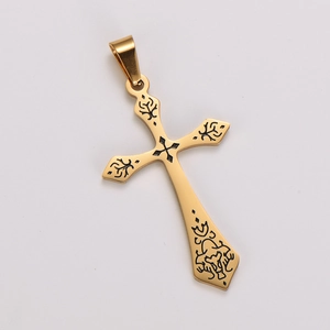 Detailed close-up of a vintage golden cross pendant with black engraved floral patterns
