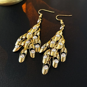 Detailed view of layered gold-tone fringe earrings with sparkling zircon crystal inlays