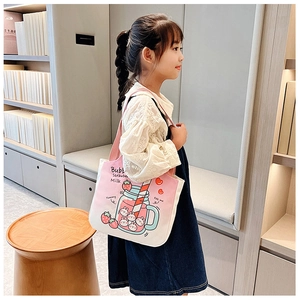 Pink and white canvas tote bag with strawberry milk rabbit pattern on a child model