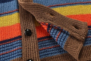 Detailed close-up of multi-color striped knit cardigan with textured fabric and black buttons