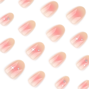 Short round press-on nails with soft pink blush gradient and white star patterns