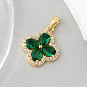 Detailed close-up of a four-leaf clover pendant with green pear-cut gems and gold plating