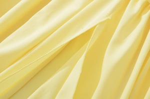 Macro di tessuto a trama giallo brillante con texture plissettata e cuciture fini