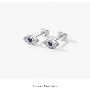 Macro shot of S925 sterling silver evil eye stud earrings with blue and white crystals