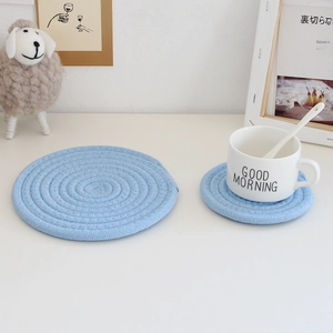 Macro shot of blue woven cotton rope coasters in two sizes for table heat protection